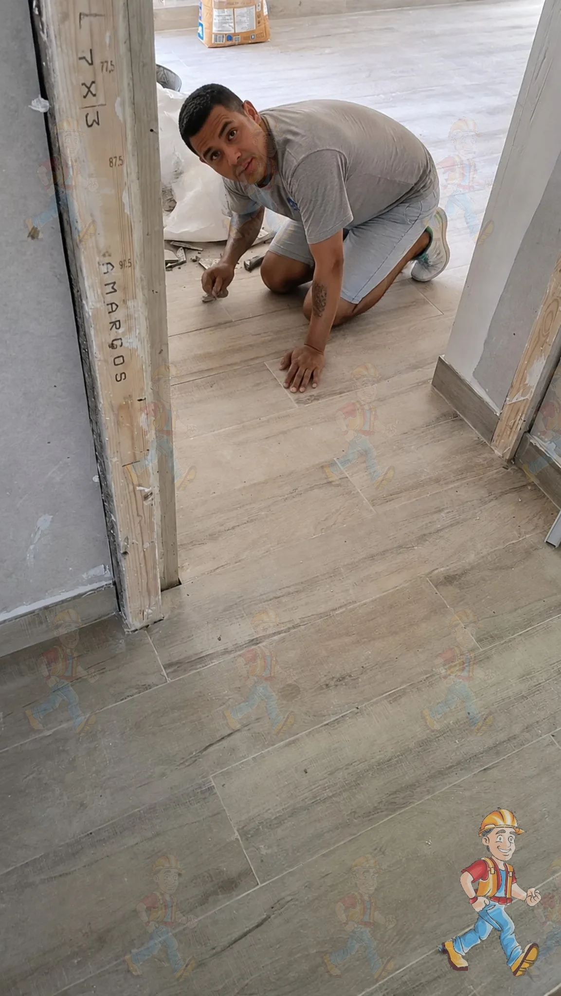 Juan colocando y ajustando el suelo símil madera durante la obra de una vivienda en Alicante
